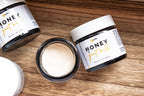 Leafia Skincare honey goat milk face and eye cream flat lay, creamy texture in amber jar on natural wood