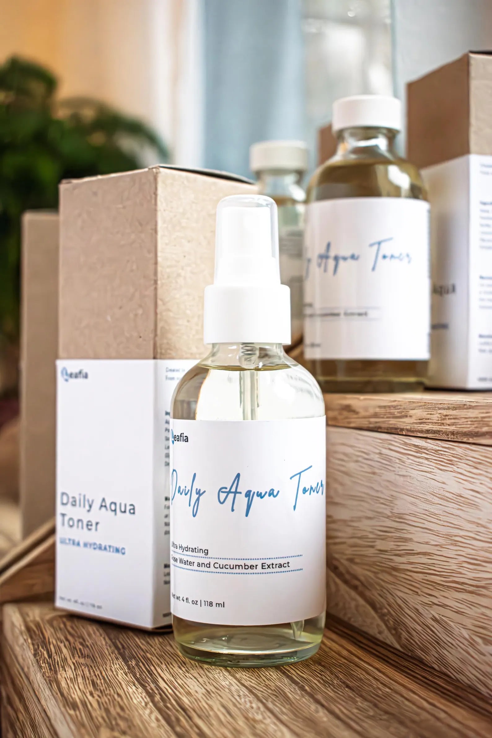 Leafia Skincare Daily Aqua Toner in clear glass bottle on wooden surface with additional bottles and packaging in background