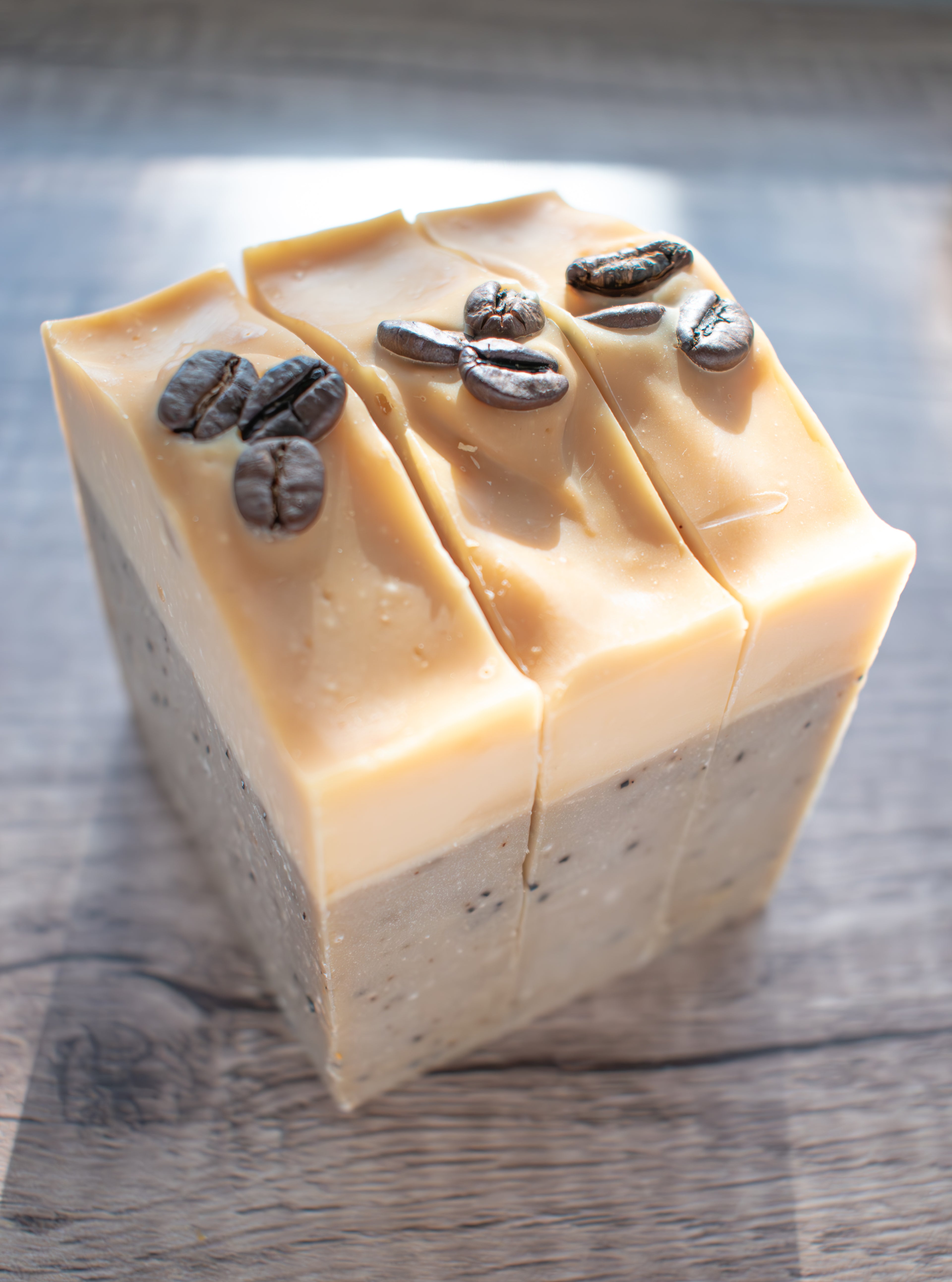 Block of soap with coffee beans on a wooden surface