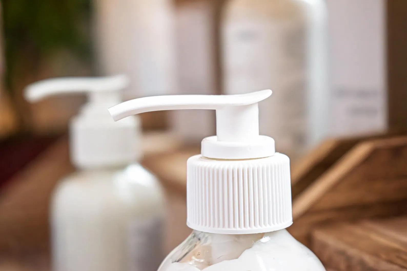Leafia Skincare grass-fed tallow body lotion creamy daily moisturizer in close-up, highlighting white pump on clear bottle