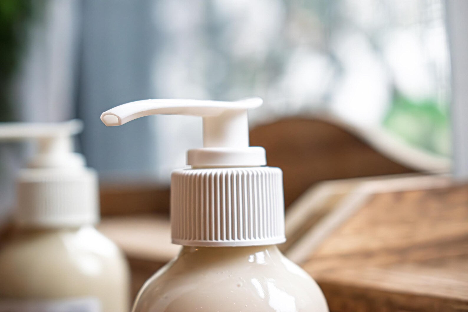 Leafia Skincare Oatmeal Cleanser in white pump bottle on wooden surface with softly blurred background