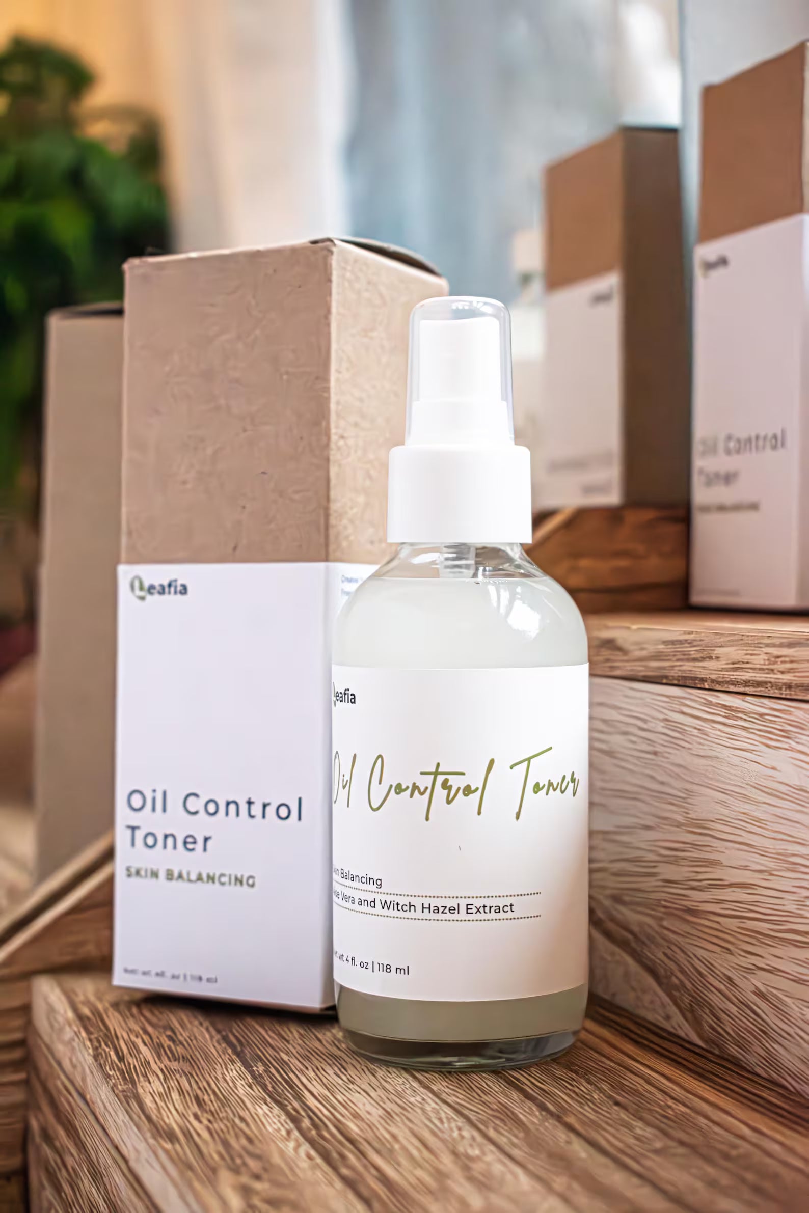 Leafia Skincare Oil Control Toner with witch hazel and aloe in clear bottle with white label, packaging on wooden surface