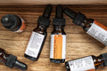 Leafia Skincare Vitamin C facial oil bottles with black droppers on wood, amber glass, white labels, minimal packaging