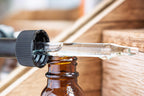 Leafia Skincare Vitamin C facial oil in glass dropper above amber bottle, highlighting texture in soft natural light