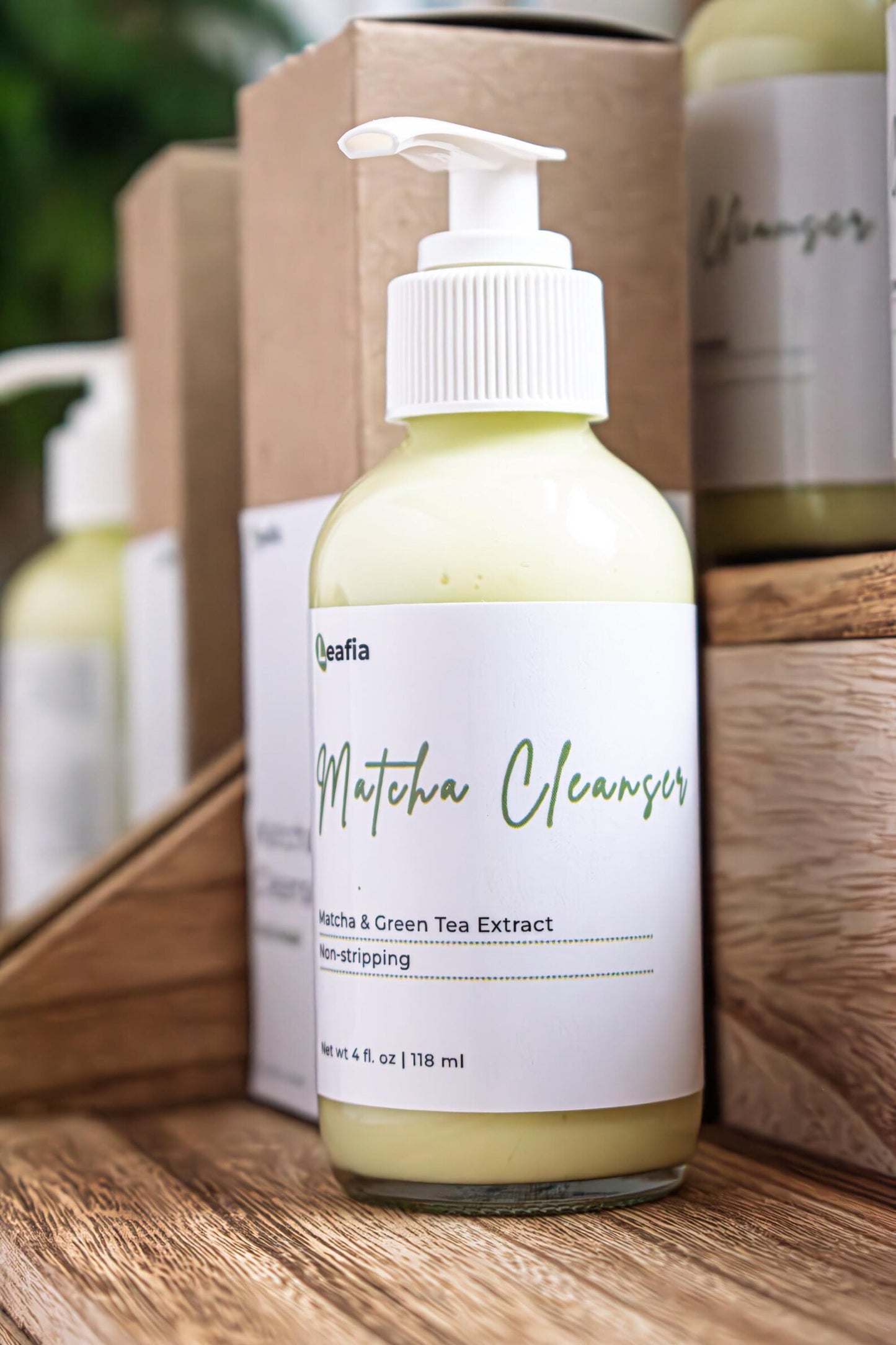 Leafia Skincare Matcha Green Tea gentle cream cleanser in clear pump bottle beside kraft box on wooden surface