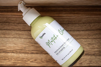 Leafia Skincare Matcha Green Tea facial cleanser bottle on wooden surface, creamy pale green formula visible through clear packaging
