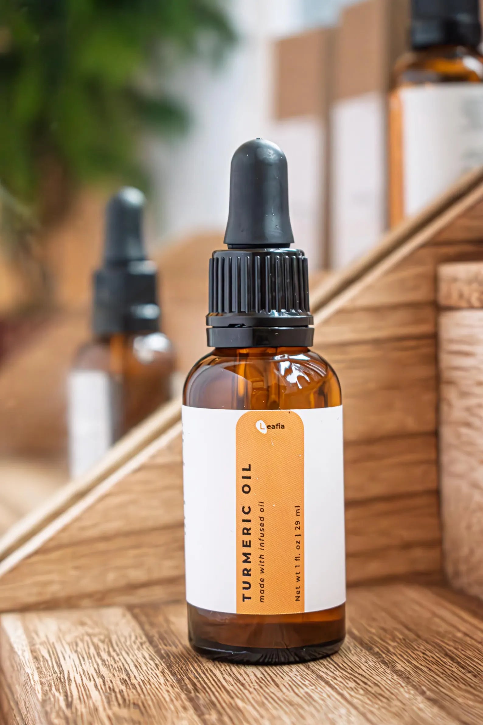 Leafia Skincare turmeric facial oil dropper bottle on wooden display, natural lightweight oil for glowing nourished skin
