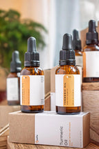 Leafia Skincare turmeric infused facial oil in amber dropper bottle with matching boxes, natural jojoba oil and vitamin E skincare