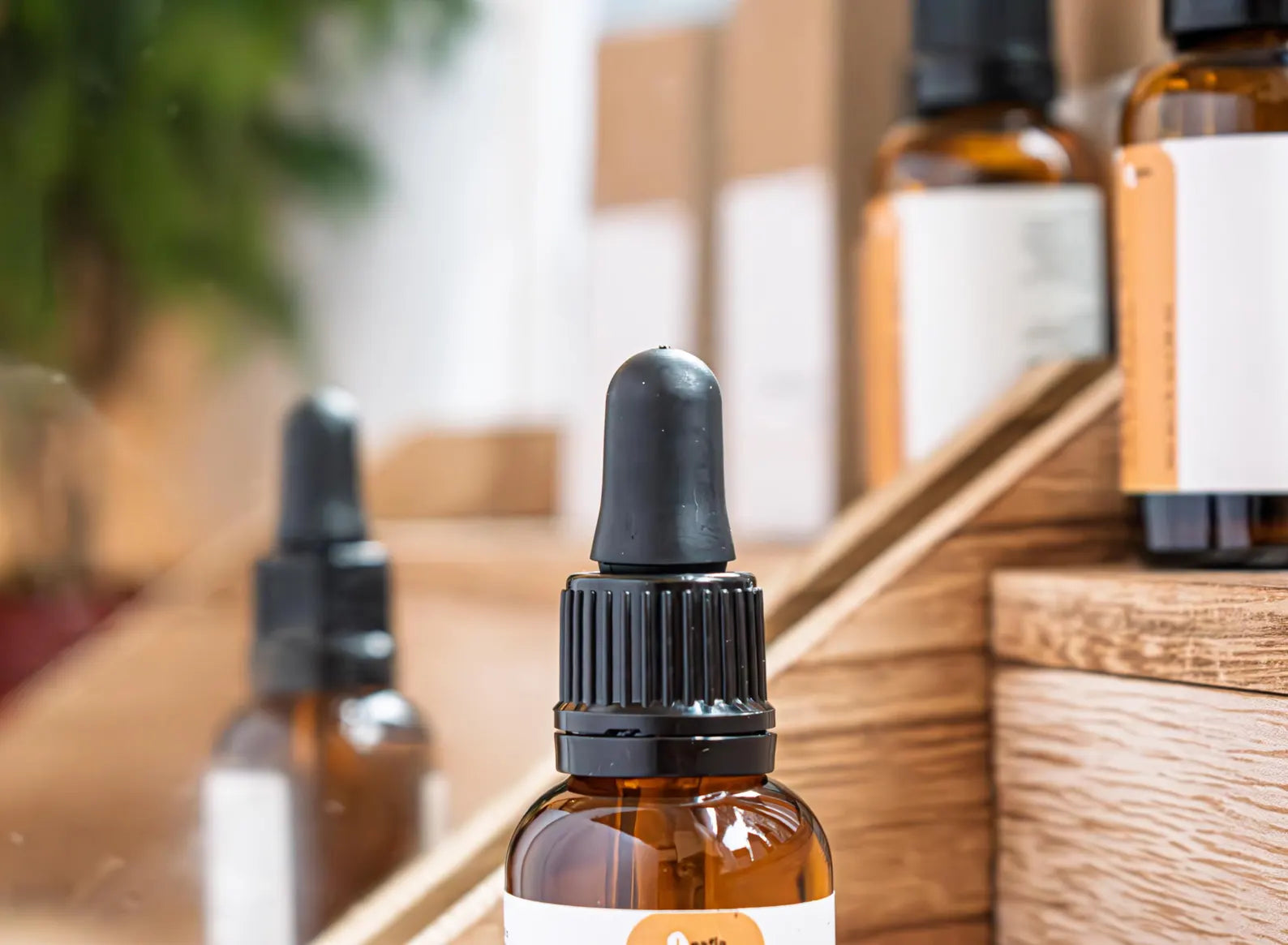 Leafia Skincare brown glass dropper bottles with black caps on wooden shelf