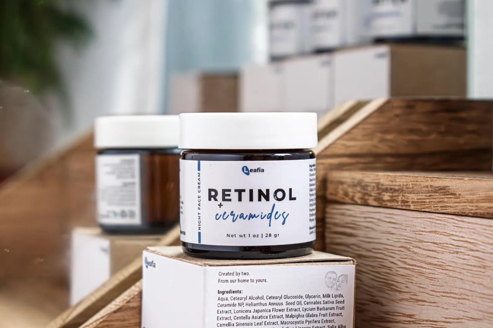 Leafia Skincare retinol cream jar on wooden surface with boxes in background
