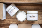 Leafia Skincare Vitamin E apricot oil lotion face and body moisturizer shown above with open jar, closed jar and packaging on natural wood
