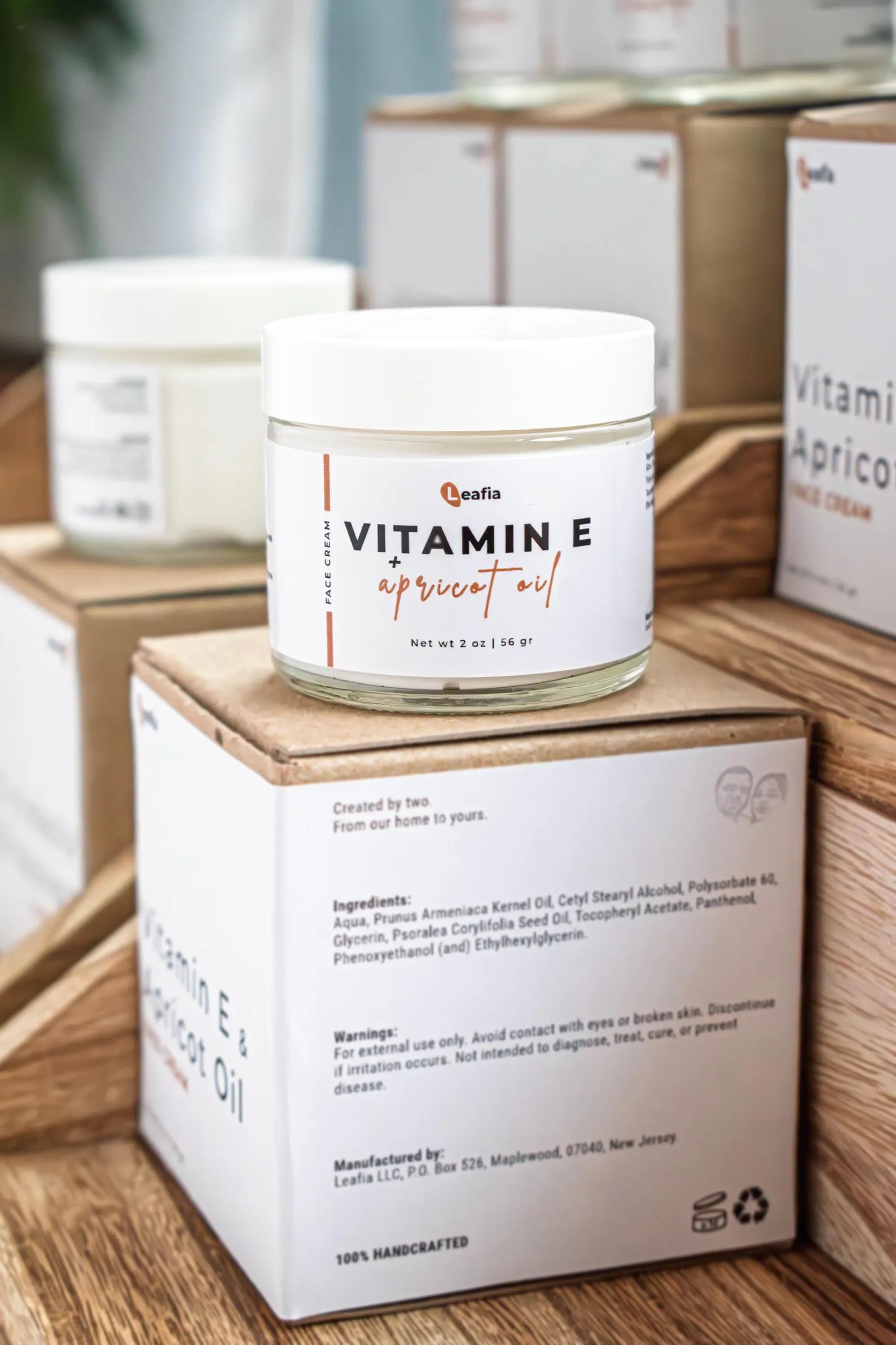 Vitamin E Apricot Oil Lotion by Leafia Skincare in glass jar beside packaging, designed for lightweight daily moisturizing