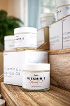 Leafia Skincare Vitamin E apricot oil lotion in white jar with packaging on wood blocks in soft natural light