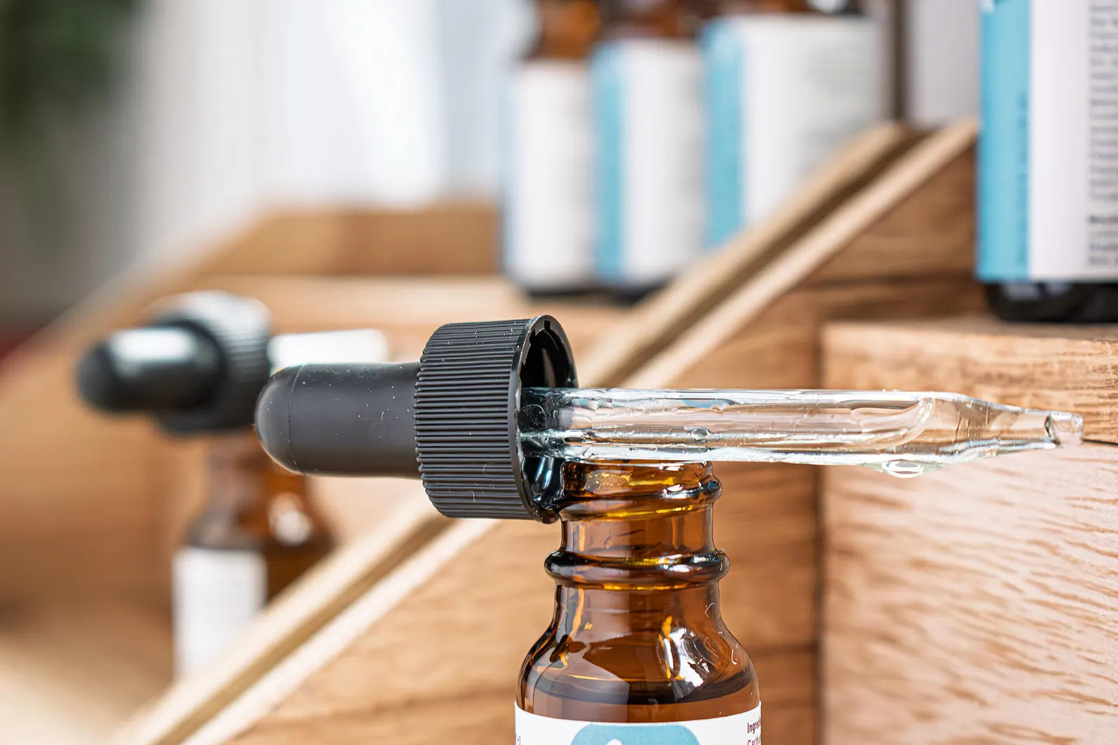 Leafia Skincare Restore Oil facial oil in glass dropper above amber bottle, highlighting texture in soft natural light