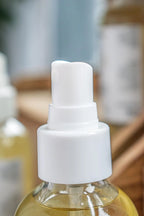 Close-up of a Leafia Skincare spray bottle with a white nozzle on a blurred background