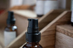 Close-up of  Leafia Skincare chamomile face serum pump top with blurred apothecary-style background