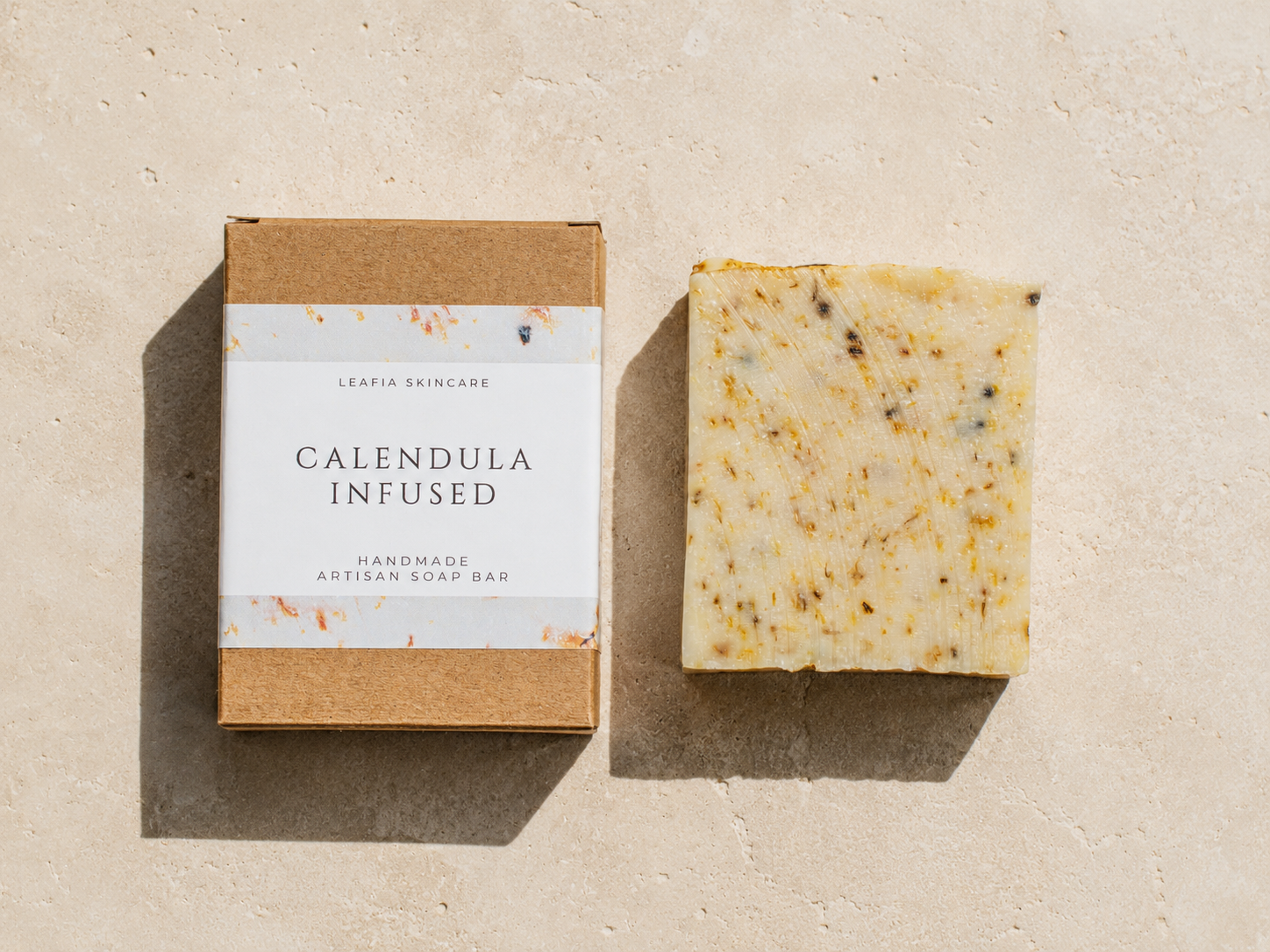 Calendula infused soap bar with packaging on a beige background