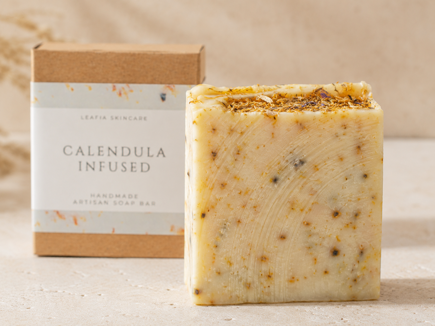 Calendula infused soap bar with packaging on a neutral background