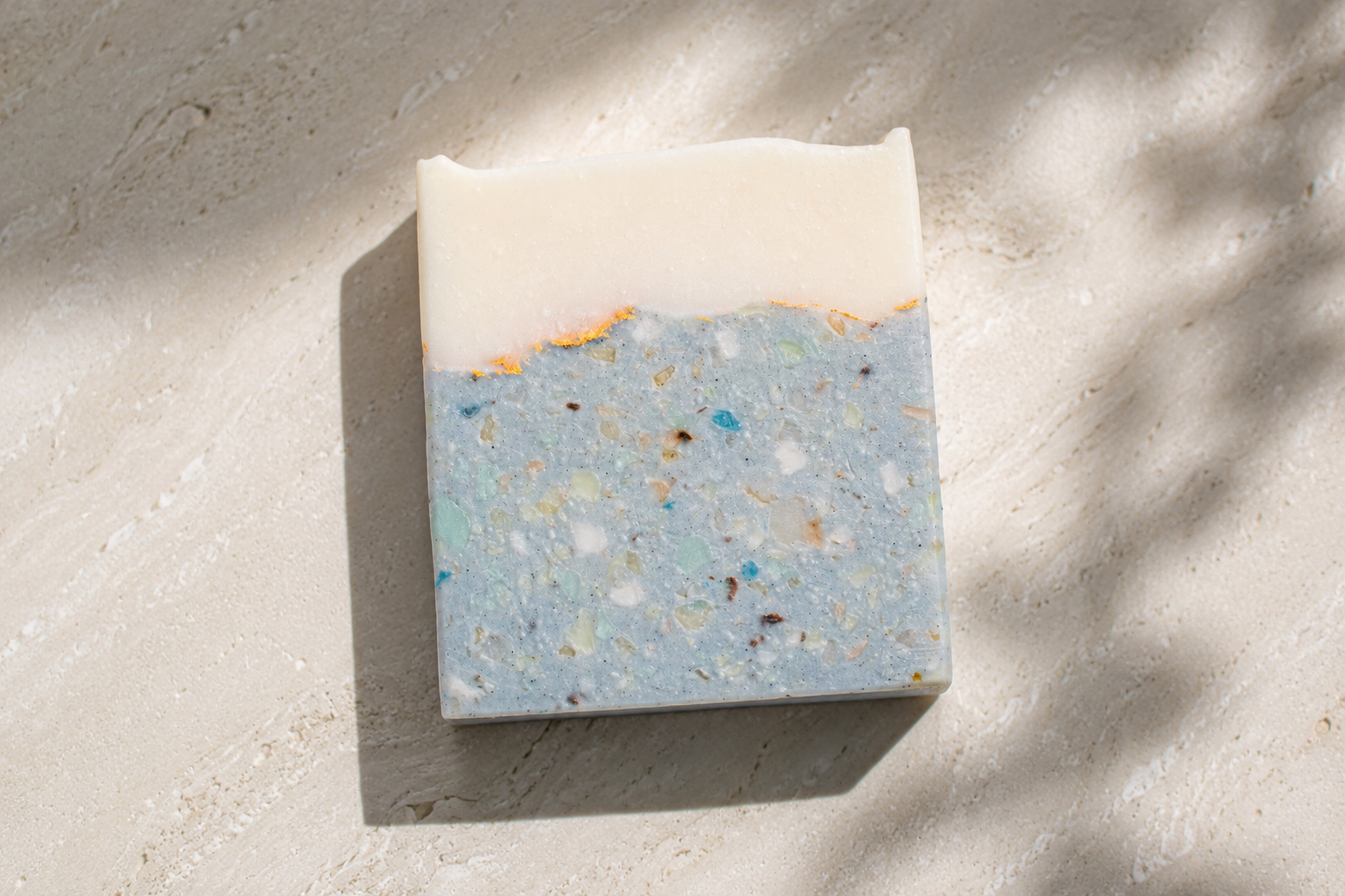 Bar of soap with a blue and white speckled design on a textured surface