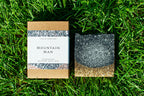 Bar of soap and packaging labeled 'Mountain Man' on grass