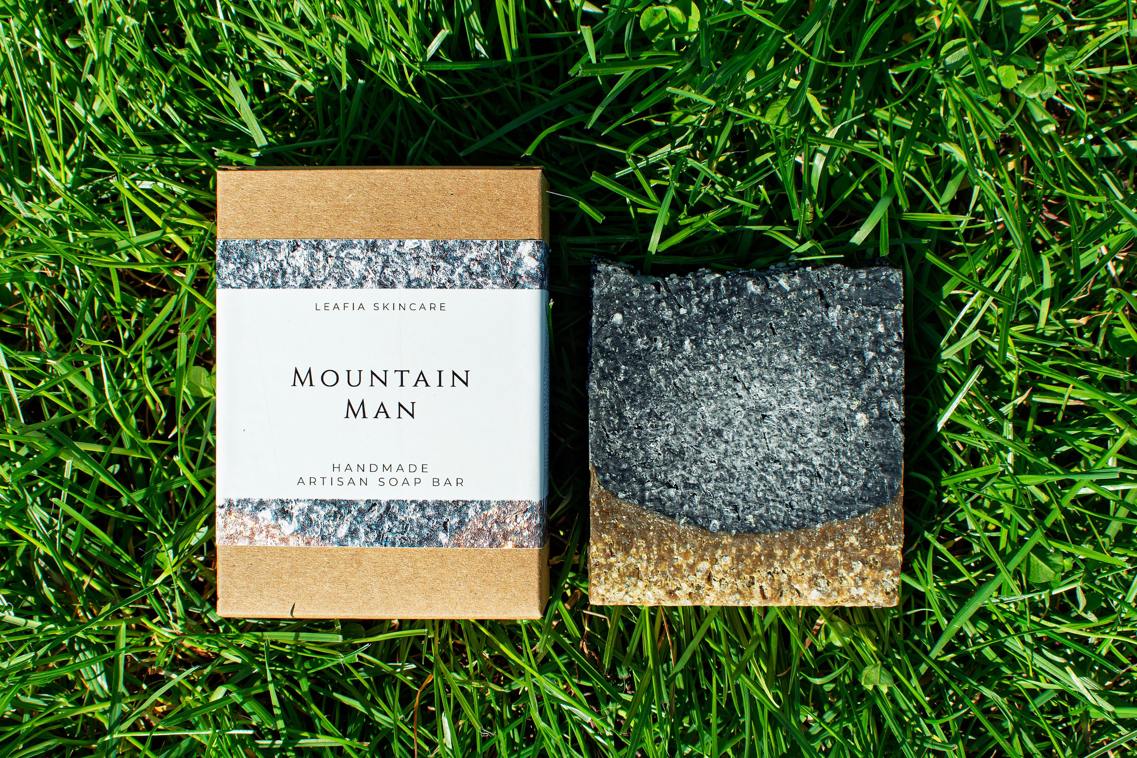 Bar of soap and packaging labeled 'Mountain Man' on grass
