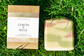 Bar of soap and its packaging on grass