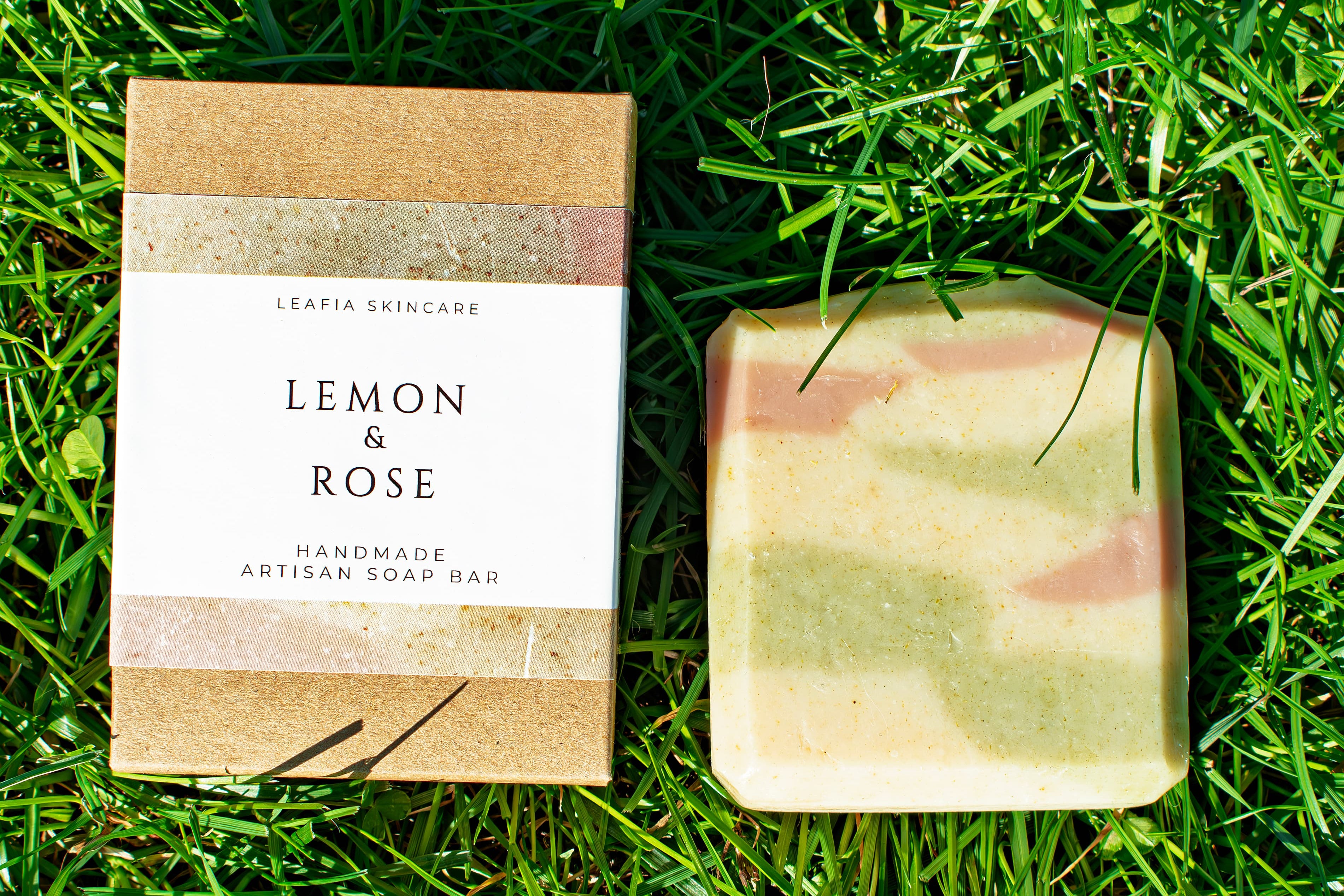 Bar of soap and its packaging on grass