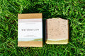 Bar of soap and its packaging on grass