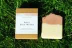 Bar of soap and its packaging on grass