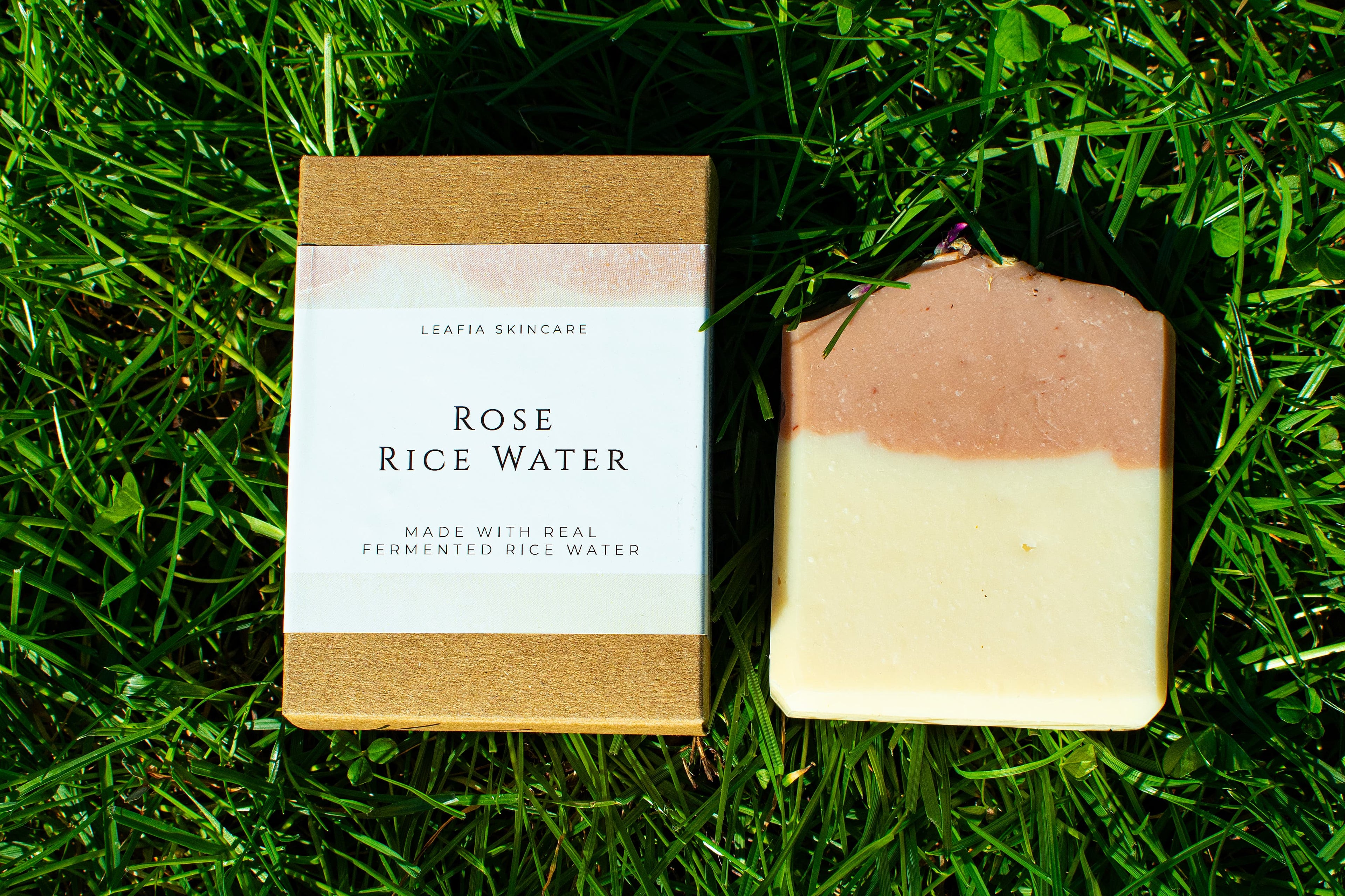 Bar of soap and its packaging on grass