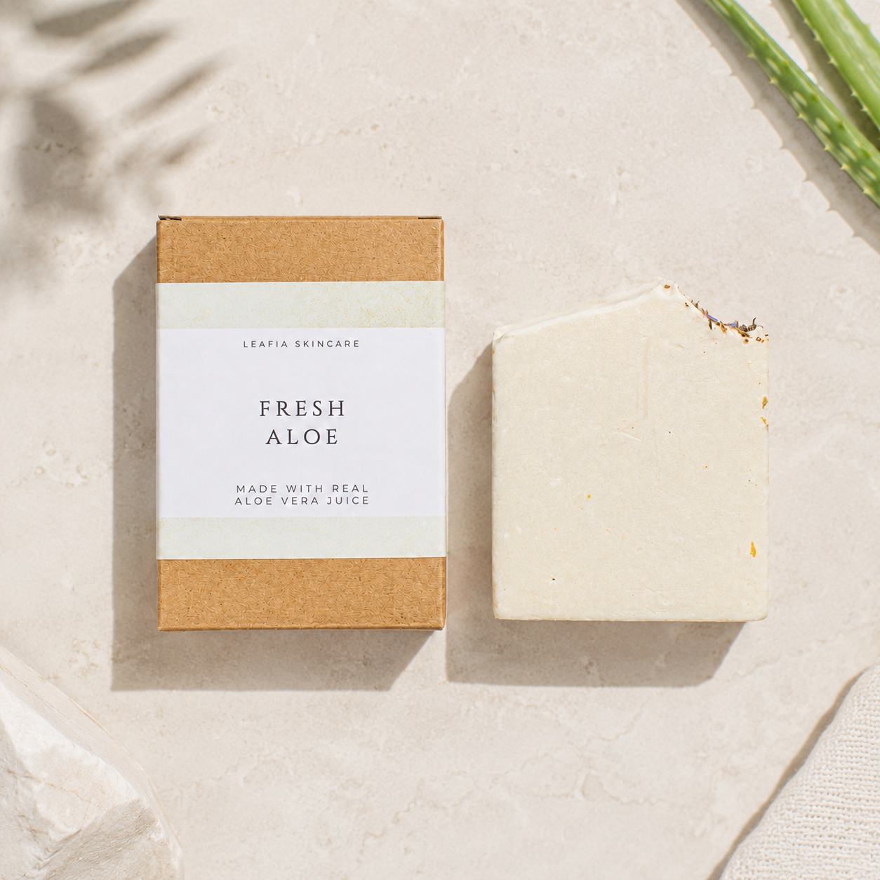 Bar of soap labeled 'Fresh Aloe' on a textured surface with a natural design.