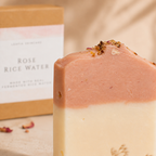 Bar of soap with rose rice water packaging in the background