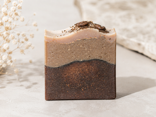 Three-layered soap bar with natural texture on a light background