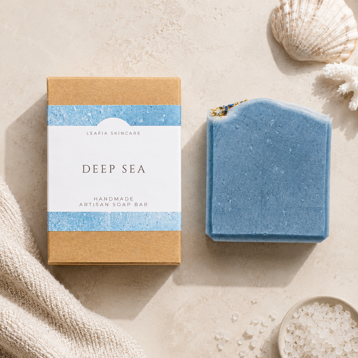 Blue soap bar with 'Deep Sea' packaging on a beige surface with shells and sand.