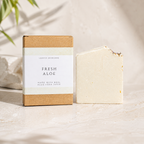 Bar of soap with a box labeled 'Fresh Aloe' on a neutral background